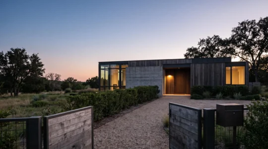 Vue nocturne d'une maison individuelle protégée par plusieurs cercles concentriques de sécurité, du portail jusqu'à la façade