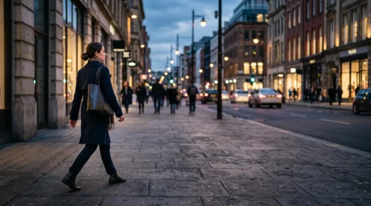 Silhouette d'une personne marchant avec une posture droite et confiante dans une rue urbaine au crépuscule